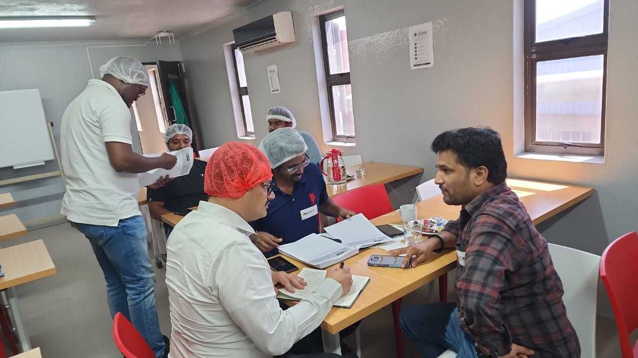 Delegates in hairnets completing a practical food hygiene exercise